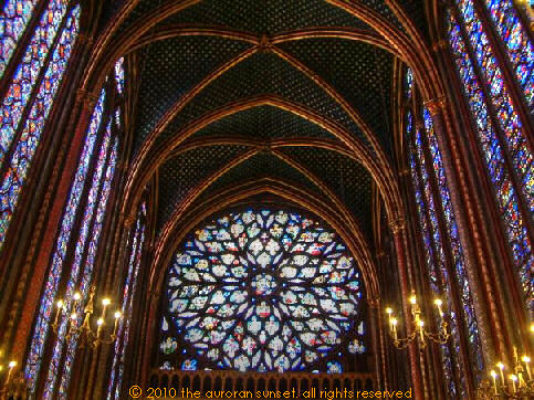 15th century Flamboyant rose window surrounded by rich, soaring stained glass and painted columns
