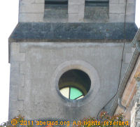 View through one open oculus to a glass-filled oculus on the other side of the church belfry.