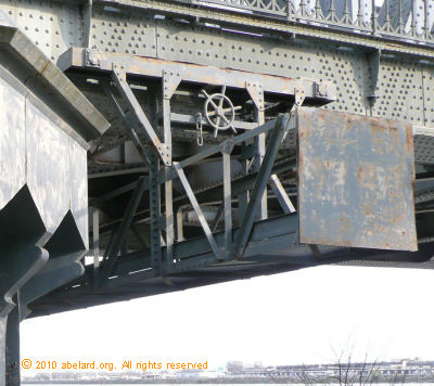 Beneath the bridge is a maintenance gantry with a handwheel to move it.